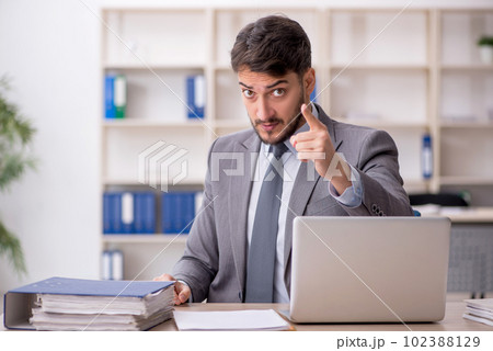 Young male employee working in the office 102388129