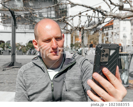 Portrait of a handsome hipster man. A man in a big city with smartphone, a life style concept Portrait of a handsome hipster man. A man in a big city with smartphone, a life style concept 102388355