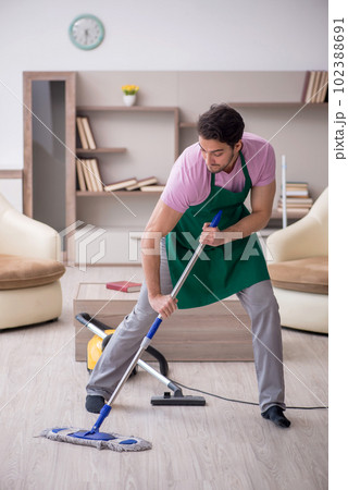 Young male contractor cleaning the house Young male contractor cleaning the house 102388691