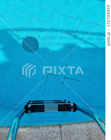 stairs for descending to the pool with a dirty floor.  102388993