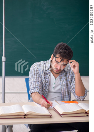 Young male teacher suffering in the classroom Young male teacher suffering in the classroom 102389197