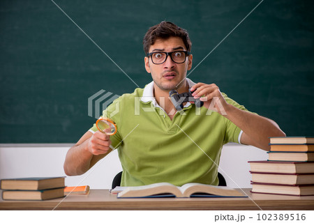 Young male student sitting in the classroom Young male student sitting in the classroom 102389516