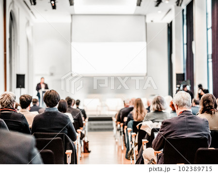 Speaker giving a talk in conference hall at business event. Rear view of unrecognizable people in audience at the conference hall. Business and entrepreneurship concept Speaker giving a talk in conference hall at business event. Rear view of unrecognizable people in audience at the conference hall. Business and entrepreneurship concept 102389715