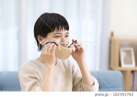 マスクを外す若い女性 102391762