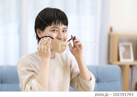 マスクを外す若い女性 102391763