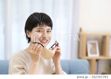 マスクを外す若い女性 102391765