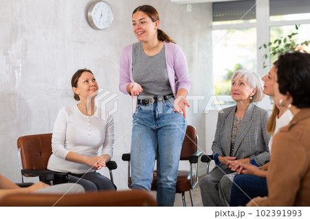 In classroom,girl stands next to colleagues and tells audience her vision of situation 102391993