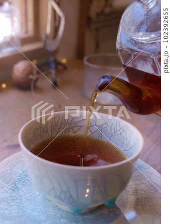 カフェの客席にてカップに注がれる紅茶　01 102392655