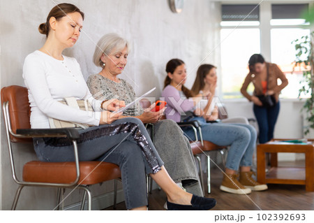 Adult woman with documents waiting for her turn on chair 102392693