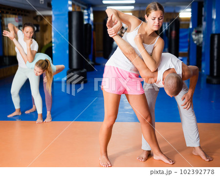 Girl performing elbow strike and wristlock to male opponent during self defence training Girl performing elbow strike and wristlock to male opponent during self defence training 102392778