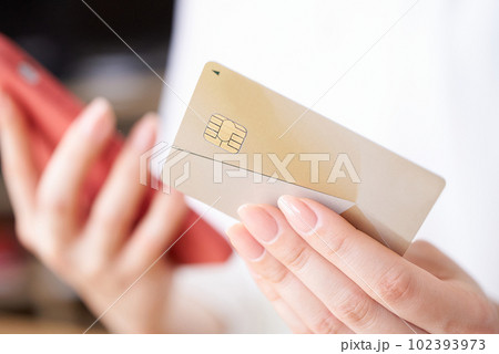 クレジットカードとスマートフォンを持つ女性の手元 クレジットカードとスマートフォンを持つ女性の手元 102393973