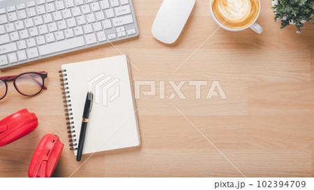 Office desk worklace with keyboard, mouse, noebook, eyeglass, pen, headphone and cup of coffee, Top view flat lay with copy space. 102394709