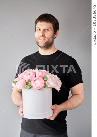Round box with Pink Angel Cheeks peonies in a men hand. Beautiful peony flower for catalog or online store. Floral shop concept . Beautiful fresh cut bouquet. Flowers delivery Round box with Pink Angel Cheeks peonies in a men hand. Beautiful peony flower for catalog or online store. Floral shop concept . Beautiful fresh cut bouquet. Flowers delivery 102396645