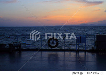 船の上から望む夕日 102396799