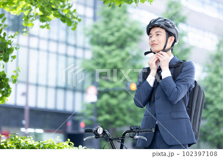 自転車通勤　ヘルメットを装着する若い男性 102397108