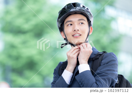 自転車通勤 ヘルメットを装着する若い男性 自転車通勤 ヘルメットを装着する若い男性 102397112