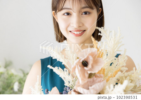 ドライフラワーの花束を持つワンピースの女性 102398531