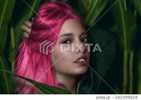 Young pink hair woman poses outdoors. 102399829