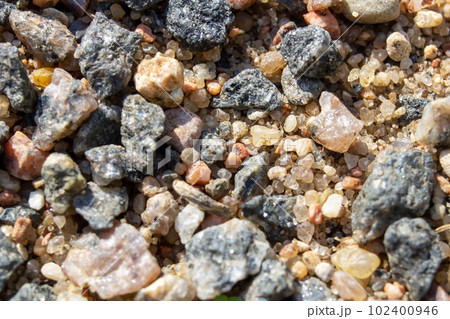 Small pebbles in the sand close up 102400946