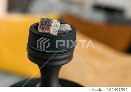 Hookah hot coals for smoking close-up and leisure in natural lighting in room Hookah hot coals for smoking close-up and leisure in natural lighting in room 102401503
