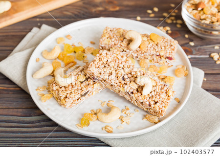 Various granola bars on table background. Cereal granola bars. Superfood breakfast bars with oats, nuts and berries, close up. Superfood concept Various granola bars on table background. Cereal granola bars. Superfood breakfast bars with oats, nuts and berries, close up. Superfood concept 102403577