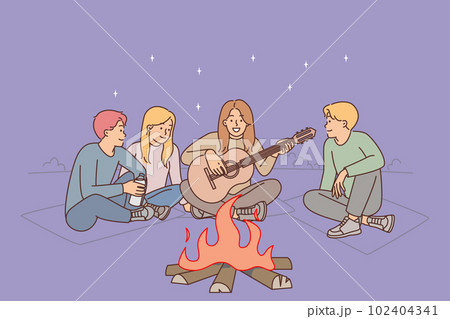 Friends are sitting around campfire with guitar enjoying camping and relaxation on evening beach 102404341