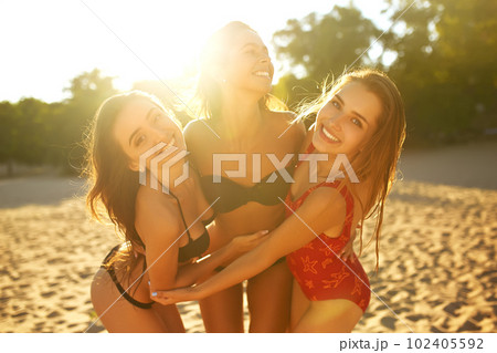 Three beautiful young girls on the beach. Excellent figures .enjoy summer time. Fun at the beach. 102405592