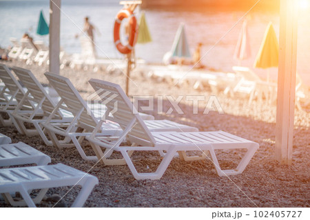 white sun loungers and an umbrella on a deserted beach. The perfect vacation concept. 102405727