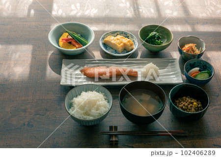 朝陽のあたるターブルに置かれた和食の朝食 102406289