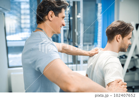 Male physical therapist working with a patient and looking invloved 102407652