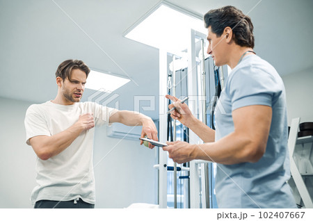 Male patient have a physical therapy session in rehabilitation center 102407667