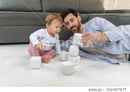 Caring young single father playing with cute kid daughter with soft blocks building tower. Caring young single father playing with cute kid daughter with soft blocks building tower. 102407675