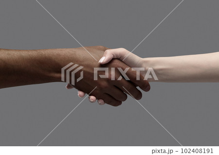Male and female hands holding, gesturing over grey background. African man and caucasian woman. Unity of races, acceptance 102408191