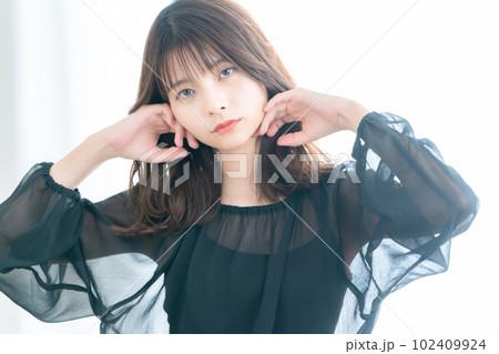 リビングの窓際でスキンケアをする若い女性 リビングの窓際でスキンケアをする若い女性 102409924