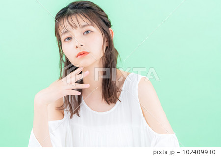 グリーンバックでスキンケアをする若い女性 102409930