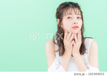 グリーンバックでスキンケアをする若い女性 102409933