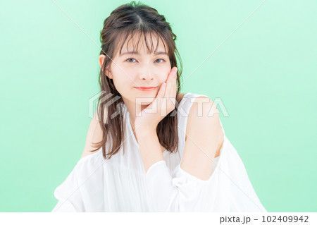 グリーンバックでスキンケアをする若い女性 グリーンバックでスキンケアをする若い女性 102409942