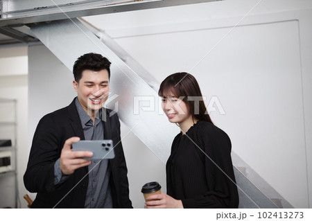 2人でスマホを見るビジネスパーソン 102413273