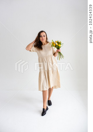 Beautiful woman with spring yellow bouquet of flowers spring and beauty concept Beautiful woman with spring yellow bouquet of flowers spring and beauty concept 102414339