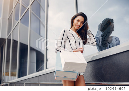 Beautiful girl in a summer city. Lady with shopping bags 102414695