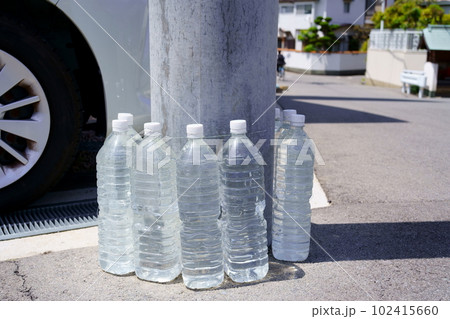 電柱を囲む犬猫よけの水入りペットボトル 102415660