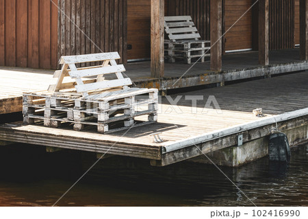 Wooden pier with a wooden chairs made from old pallets 102416990