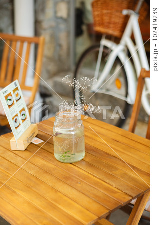a vase of flowers on a table in a cafe outside a vase of flowers on a table in a cafe outside 102419239