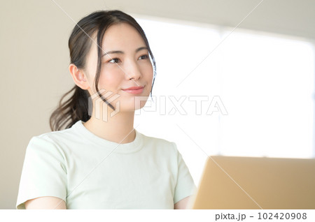 ノートパソコンの前に座る若い女性 102420908