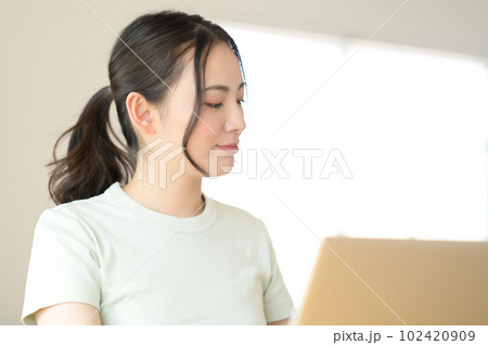 ノートパソコンの前に座る若い女性 ノートパソコンの前に座る若い女性 102420909