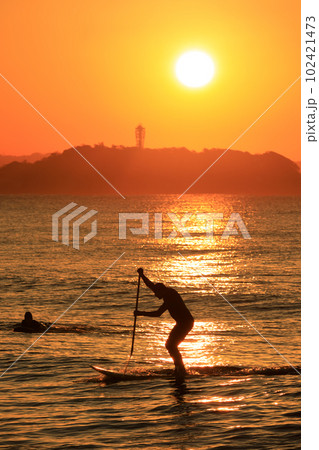 神奈川_江の島灯台の朝日とマリンスポーツを楽しむ人々 102421473