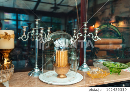 Vintage candle holder on wooden table with glassware. Stylish cafe or antique exhibition Vintage candle holder on wooden table with glassware. Stylish cafe or antique exhibition 102426359