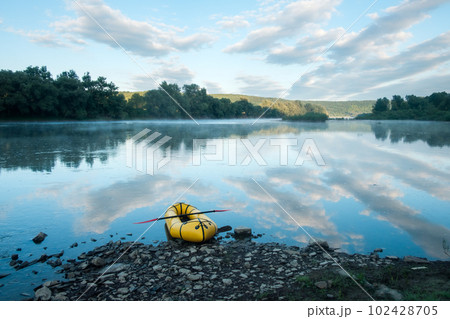 Yellow packraft on beautiful sunrise river 102428705