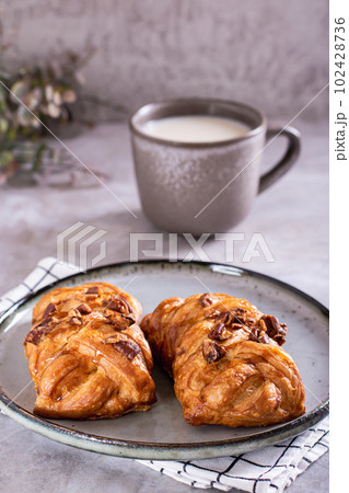Wicker buns with cinnamon, nuts and maple syrup and a cup of coffee for Swedish fika time vertical 102428736