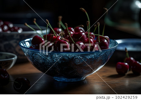Ripe appetizing cherries in a large transparent glass bowl on the table made with generative AI 102429259